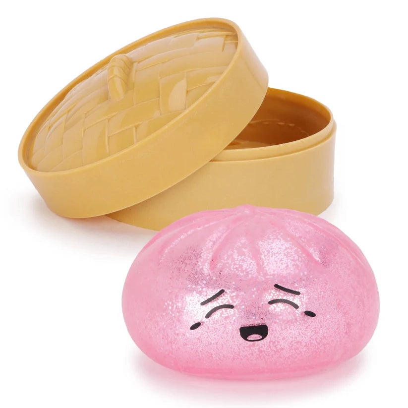 Pink glitter squishy dumpling sensory toy with a cute smiling face and storage case, designed for tactile fidget play and stress relief.