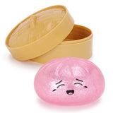 Pink glitter squishy dumpling sensory toy with a cute smiling face and storage case, designed for tactile fidget play and stress relief.