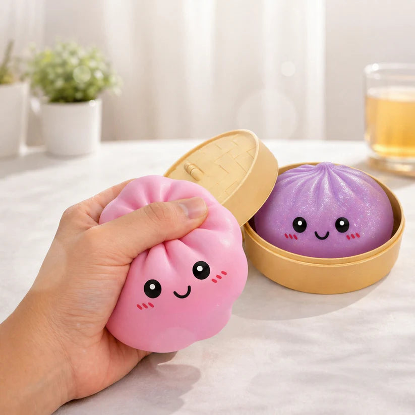 Pink and purple squishy dumpling sensory toys with cute smiling faces and storage case, designed for tactile fidget play and stress relief.